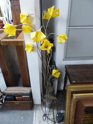 un vase contenant des fleurs jaunes, posé par terre