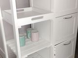 a white kitchen island with shelves and drawers on it