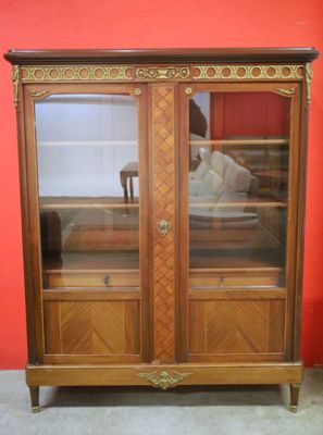 an image of a wooden cabinet with glass doors in a room