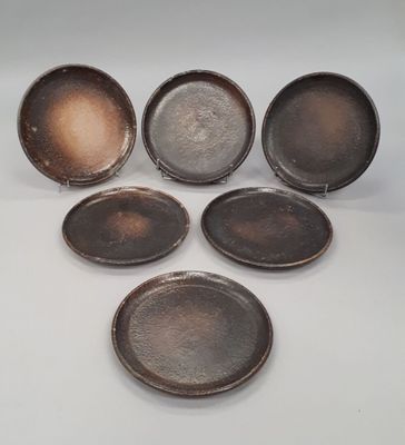 six antique cast iron pans on a white background