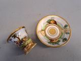 a small cup and saucer sitting on a table