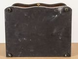 an old black suitcase sitting on top of a table next to a white wall