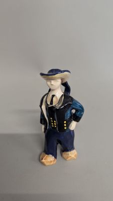 a figurine of a man wearing a hat and jacket