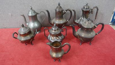 un service à thé et à café en argent composé de six pièces, posé sur une nappe rouge