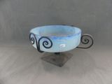 a blue bowl that is on a metal stand