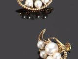 deux paires de boucles d'oreilles en perles et en or posées sur un fond noir