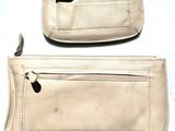 two white purses sitting next to each other on a table