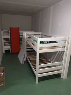 a bunk bed in the middle of a room with a red door