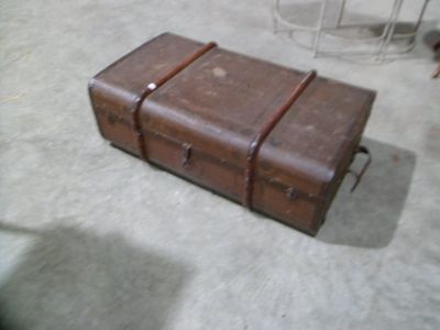 une valise marron posée sur le sol à côté d'une cage