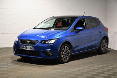 une voiture bleue garée dans un garage au sol en damier