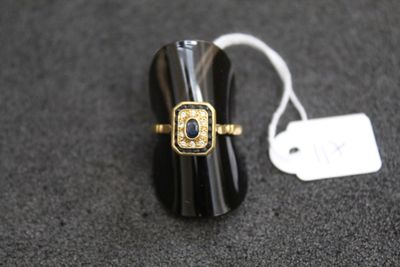 une image représentant une bague noire et dorée ornée d'une pierre bleue