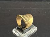 une bague en or posée sur un bloc de verre
