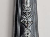 a silver spoon with a gold handle hanging on a wall