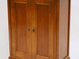 a small wooden cabinet with a door on top of it