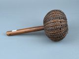 une petite pipe avec un manche en bois posée sur une surface grise