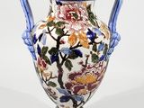 a vase with a floral design on it sitting on a table