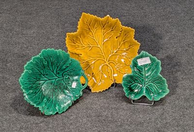trois plats verts et jaunes en forme de feuille posés sur une surface grise