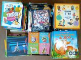 many children ' s books in a box on the floor