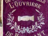 an old purple banner with writing on it on a wall