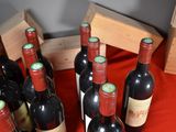 several bottles of wine are lined up on a red table cloth