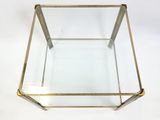 an image of a glass and brass coffee table on a white background