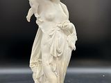 une image représentant une statue blanche d'une femme tenant une fleur