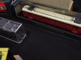 trois trains miniatures exposés sur une table noire