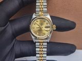 someone is holding a watch in their hand on a table