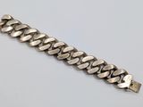 a close up of a silver bracelet on a white surface