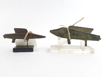 two small wooden airplanes on display on a white surface