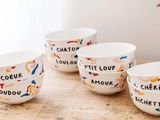 quatre bols blancs ornés de motifs différents, posés sur une table