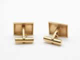 two pairs of gold cufflinks on a white background
