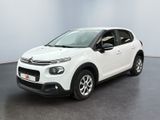 Une Citroën blanche est garée dans une pièce blanche