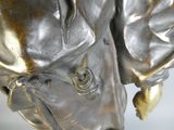 une statue en bronze représentant un homme portant un chapeau et une cravate