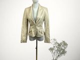 jacket on a mannequin stand with a vase of flowers in the background