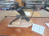 une statue en bronze représentant un homme tenant un arc et une flèche