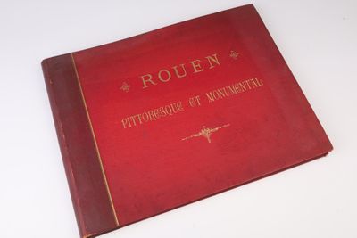 un vieux livre rouge posé sur une table blanche