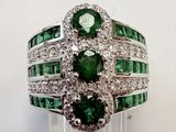 un gros plan d'une bague sertie d'émeraudes et de diamants