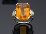 a ring with an orange stone surrounded by pearls