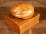 a wooden sculpture of a cat sitting on a wooden block