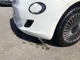 a small white car parked on the side of the road