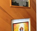 two framed pictures of a dog and a cat hanging on a wall