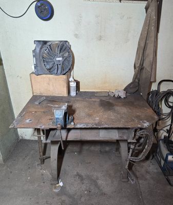 une table sur laquelle est posé un ventilateur, dans une pièce