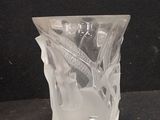 a glass vase with a toothbrush in it on a black surface