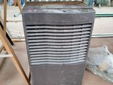a small air conditioner sitting on the floor next to a chair
