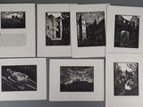 Plusieurs photographies en noir et blanc sont accrochées sur un mur gris.