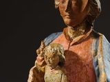 statue of a woman holding a baby in her arms with a black background