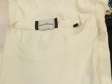 two white t - shirts with blue trims are sitting on a table