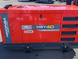 a close up of a small red generator in a parking lot