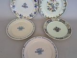 four plates with floral designs are arranged on a white surface